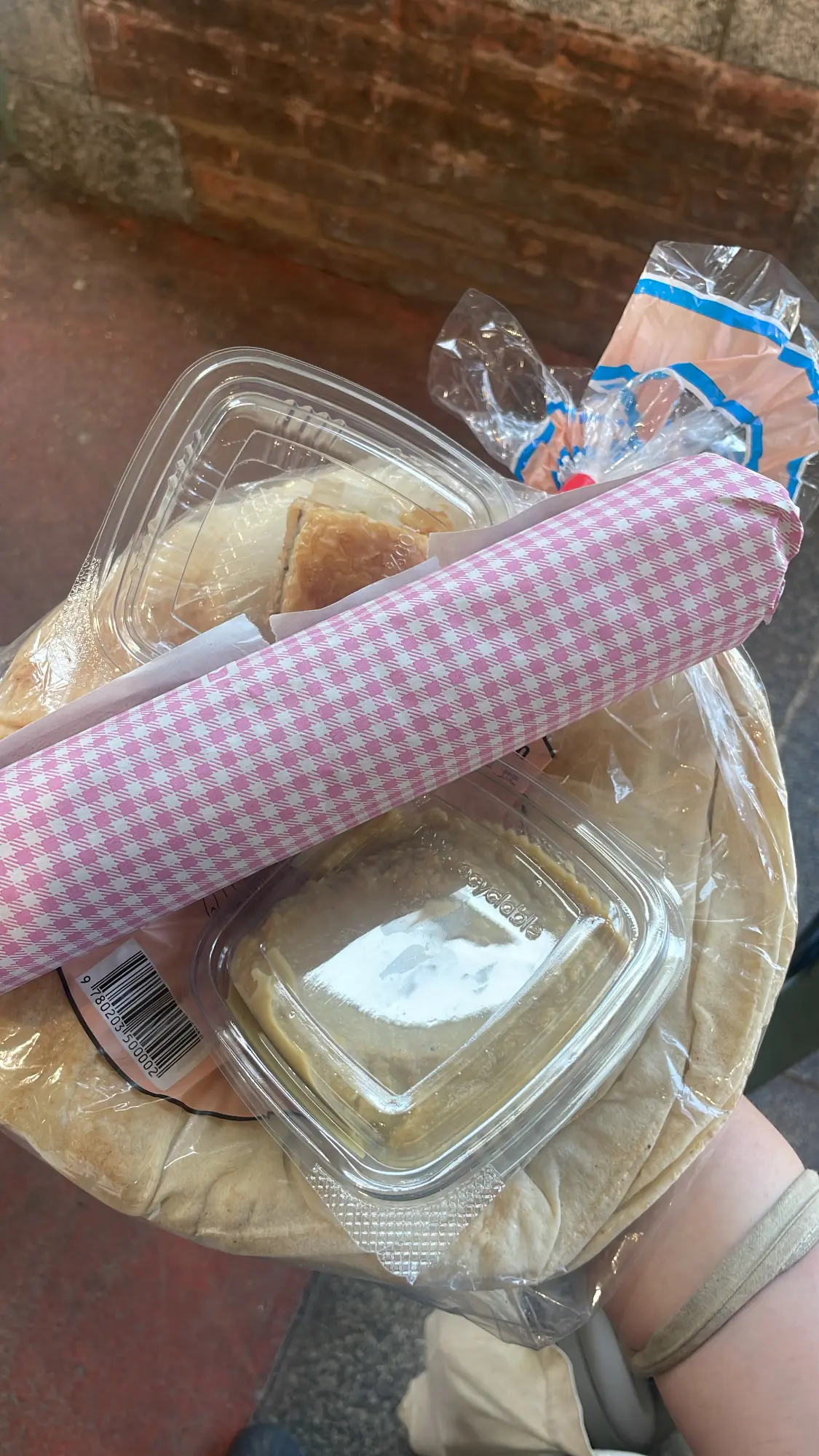 une barquette de houmous, un gâteau (baklava) un sandwich falafel et du pain
